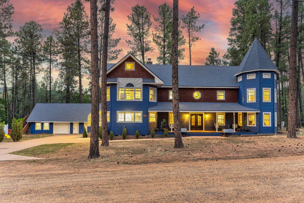 Strawberry Pines Retreat illuminated at twilight among tall pine trees.